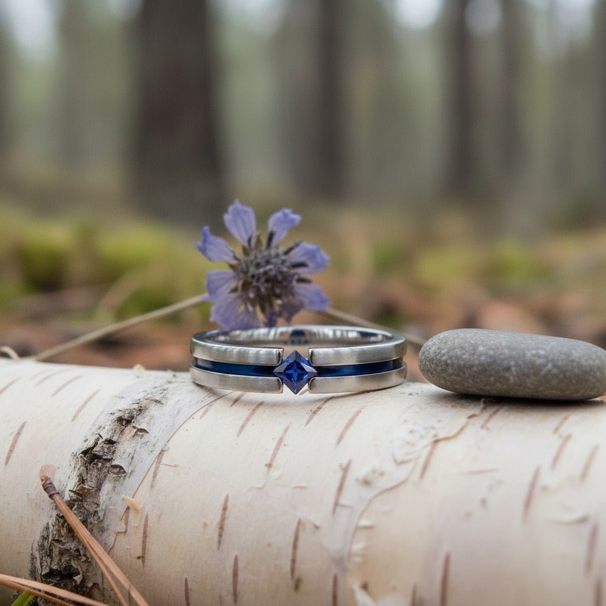 Aydins NYMERIA | Titanium Ring Blue Sapphire lifestyle scene, river birch bark