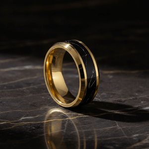 PAVO — Luxury 3/4 angle on dark marble — men's tungsten wedding ring.