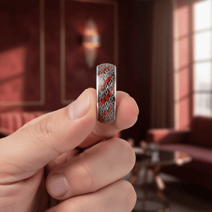 SCARLETLINK — Held between fingers close-up — men's tungsten wedding ring.