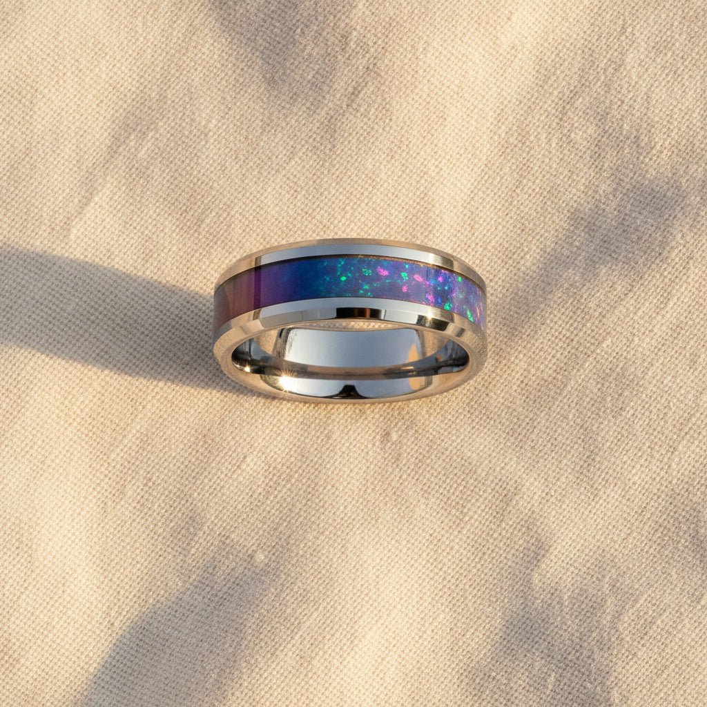 STINGRAY silver tungsten carbide wedding band with blue and purple color-changing opal inlay running around the band and polished edges macro detail overhead flat lay
