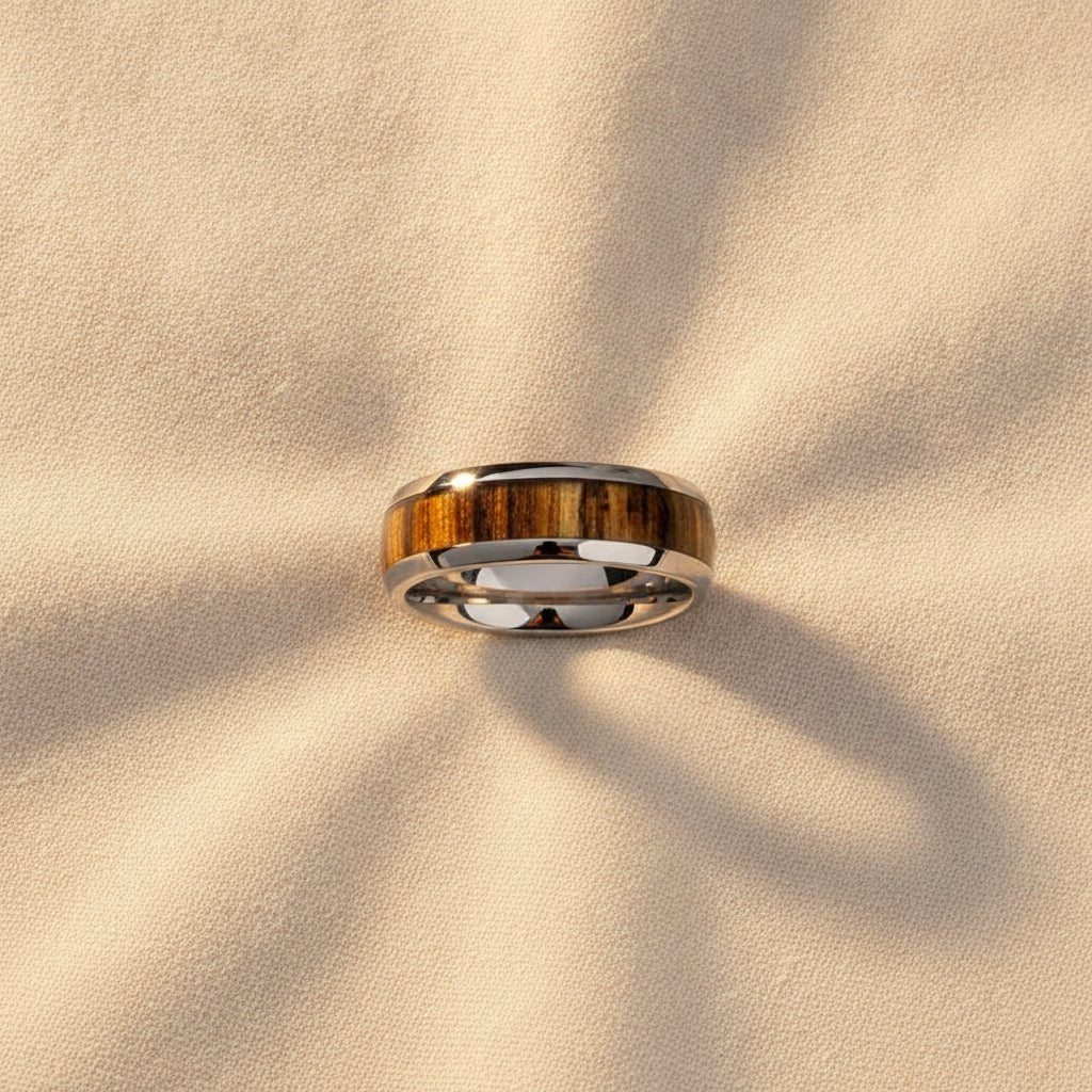 TIGRE silver tungsten wedding band with striped zebra wood inlay running around the band and polished edges macro detail overhead flat lay