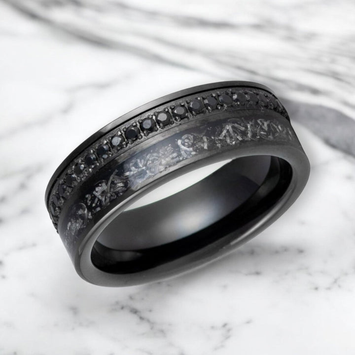 Close-up of black diamond-simulated eternity channel and titanium shavings on tungsten ring.