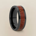 TRIASSIC black ceramic ring with red dinosaur bone inlay running around the band and polished beveled edges, studio hero shot