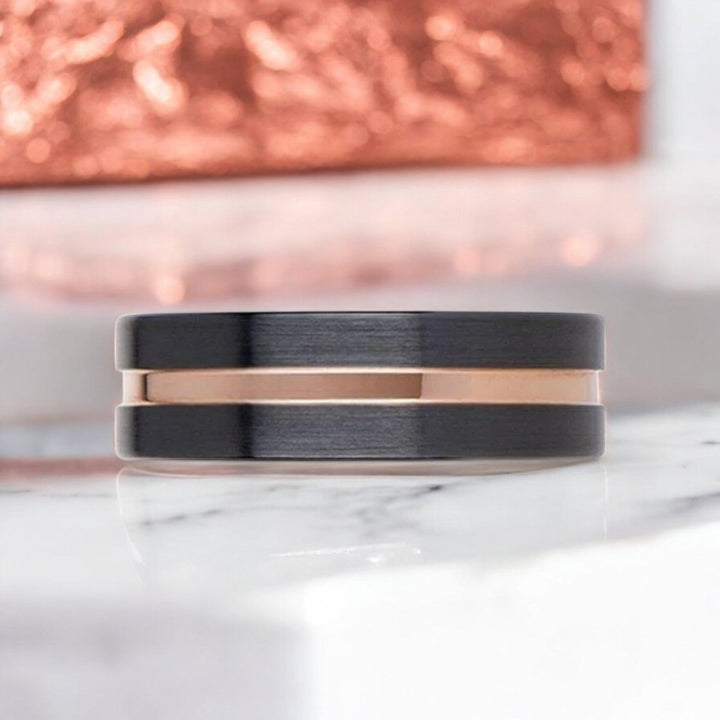 Modern flat black ceramic ring with a striking rose gold groove, perfect for weddings or special occasions.