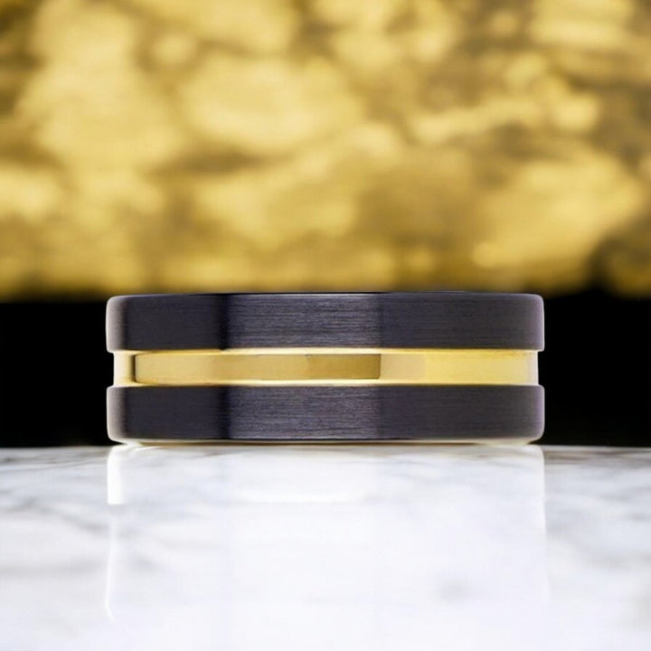 Modern black ceramic ring with luxurious yellow gold groove, perfect for weddings or special occasions.